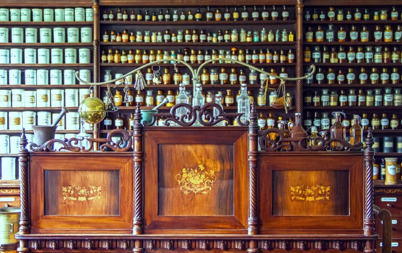 Antique apothecary shop interior with shelves of labeled medicine bottles and jars
